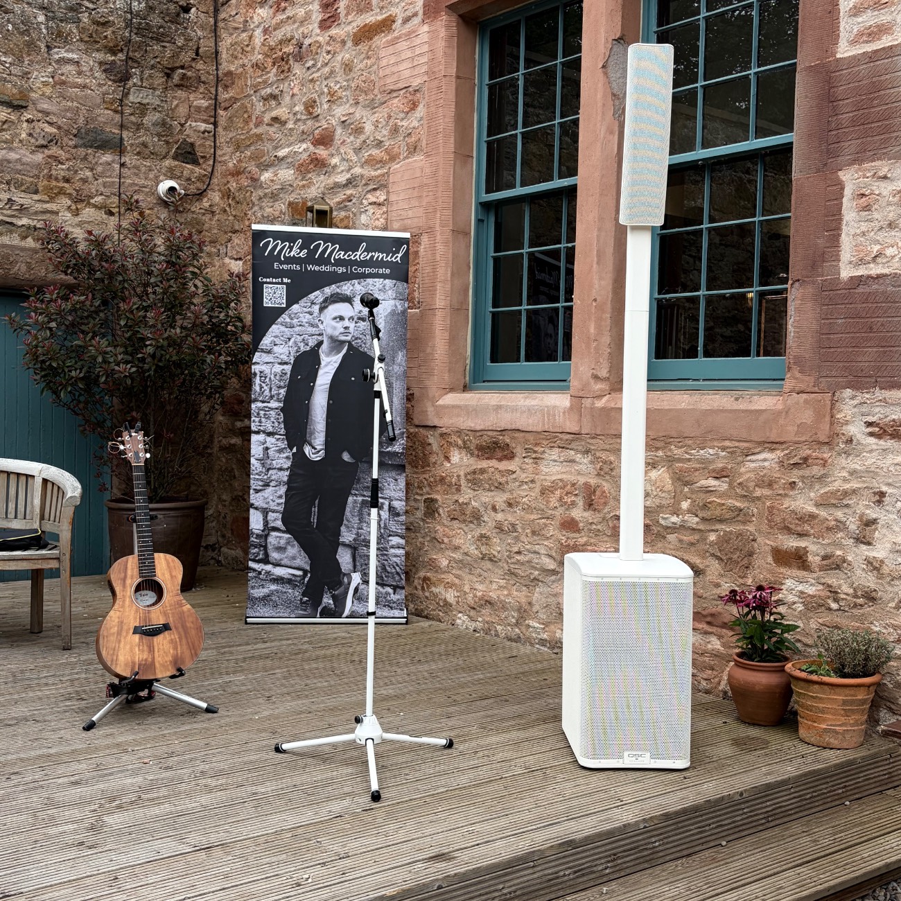 The discreet all-white sound system set up at a wedding ceremony
